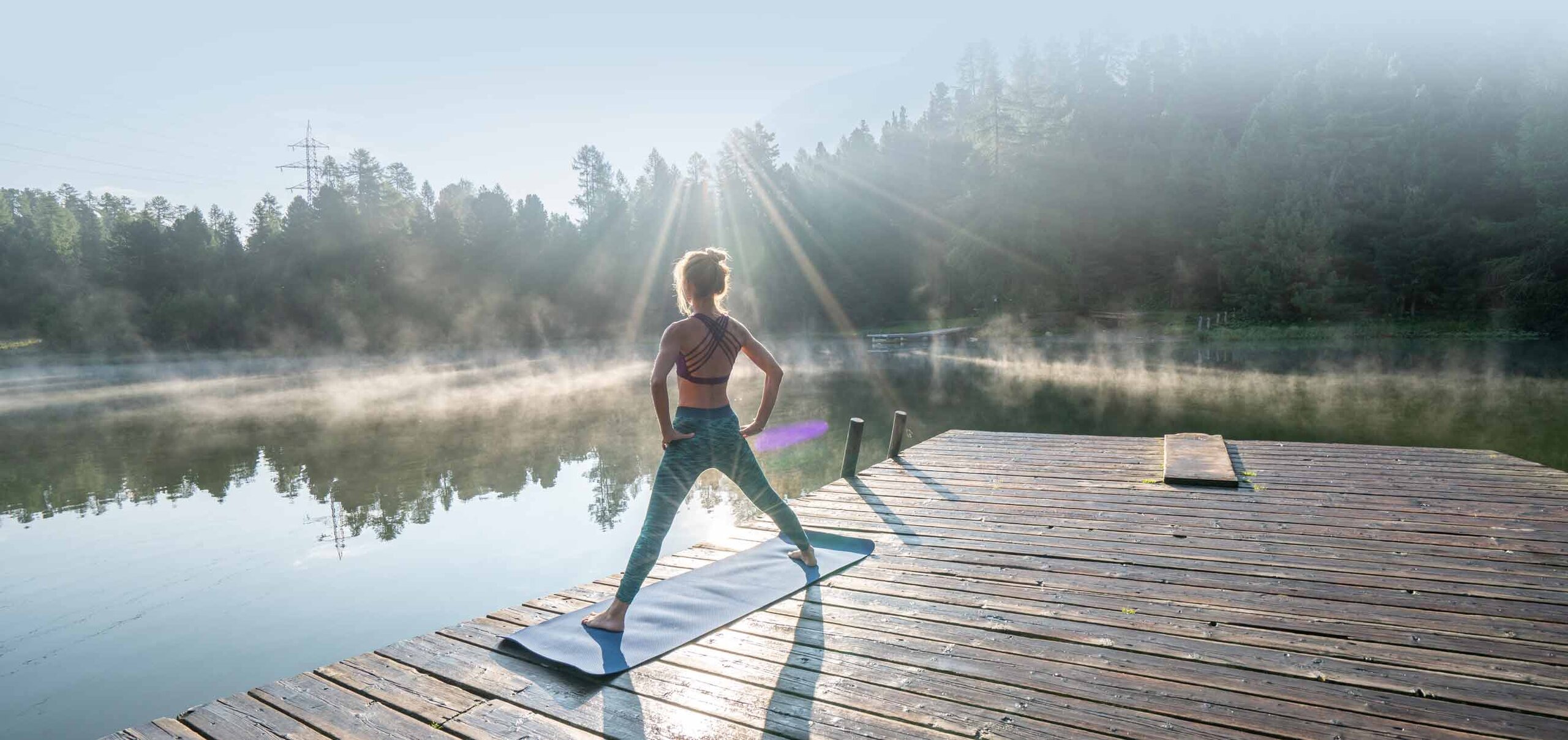 Frau macht Yoga am See
